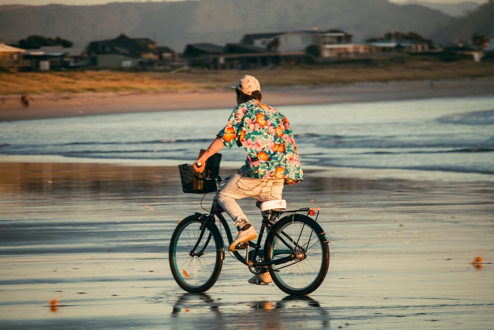 man riding bike on the beach